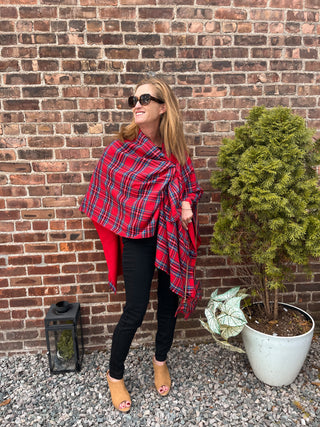 Woman wearing red plaid Keyhole Ruana wrap styled with black pants and tan shoes.