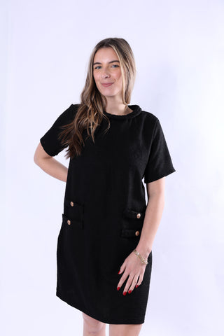 Woman wearing a black dress with buttons on a white background