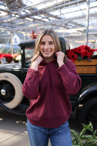 Women wearing a maroon hooded sweater