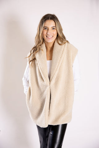 Wilson Sherpa Vest in cream with front closure and side pockets, styled over white shirt.