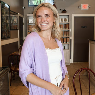 Woman wearing lavender colored shawl with white tank top