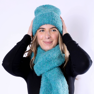 Image 5 (teal hat + scarf set): Woman smiling in teal Poppy Hat and scarf, cozy and stylish winter accessory set.