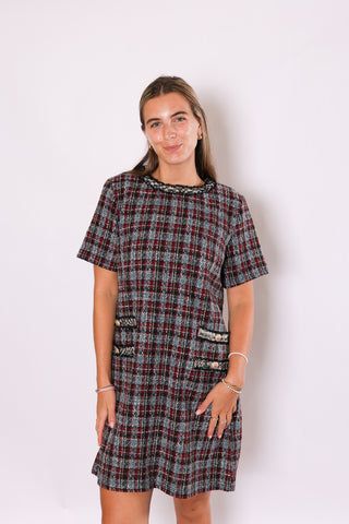 Woman wearing a plaid dress against a white background