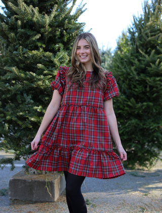 Woman wearing red tartan plaid dress while holding a present