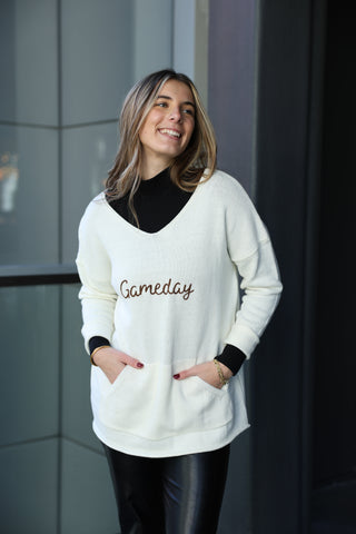 women wearing white sweater with words gameday across chest 