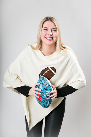 Woman wearing white poncho with a football on it