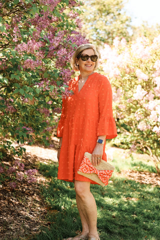 woman wearing an orange dress with swiss dots