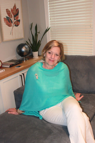 woman wearing a hydrangea blue poncho and brooch