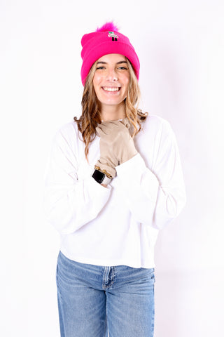 Person wearing a pink beanie, white shirt, and blue jeans on a white background