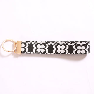 Printed keychain in black and white floral pattern.