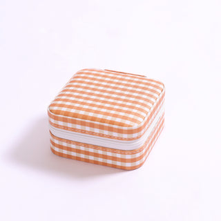 Burnt orange gingham patterned jewelry organizer with secure zip closure.