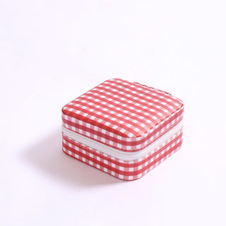 Small square jewelry travel box in red gingham pattern with white zipper.