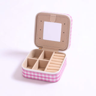 Pink gingham jewelry case shown open with built-in mirror and divided compartments.
