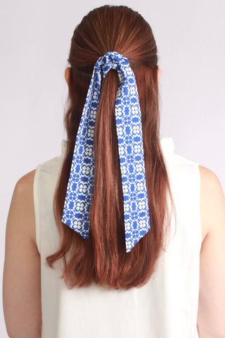 Woman wearing a blue geometric floral lace twillie in her hair