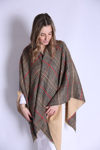 Woman wearing camel plaid Ruana styled over white pants