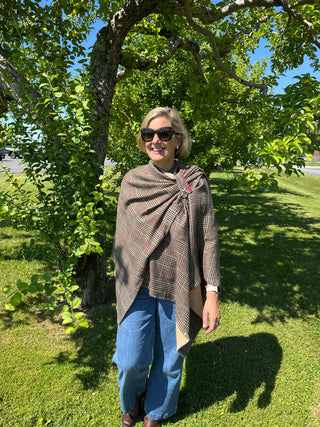 Woman wearing camel plaid Ruana styled over jeans