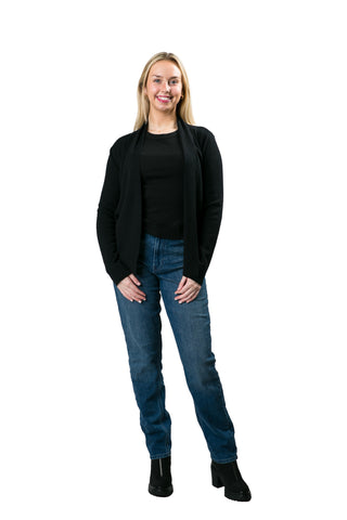 Woman in a black open front cardigan styled with a black t-shirt and blue jeans