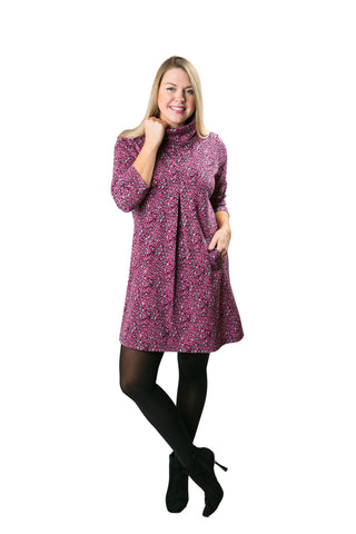 Model wearing The Meghan Dress in the pink leopard print with 3/4 sleeves, turtleneck, and pockets.