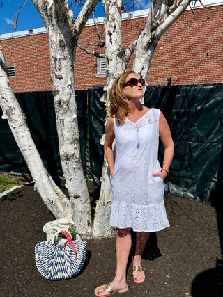 Woman wearing white ruffle trim mini eyelet cover-up with V-neck and drop waist.