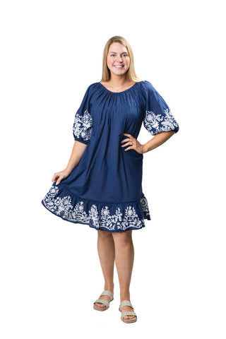 Woman wearing a blue dress with white floral patterns on a white background