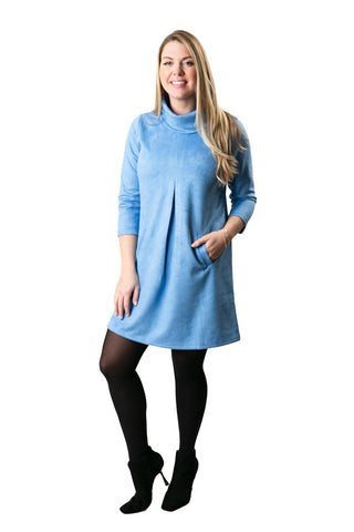 Model wearing the Hilary Dress in light blue faux suede with turtleneck, front pleat, and side pockets – stylish and flattering fall dress