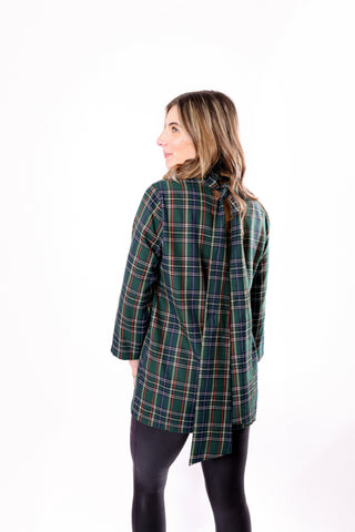 Woman wearing a green plaid ctop with a back tie