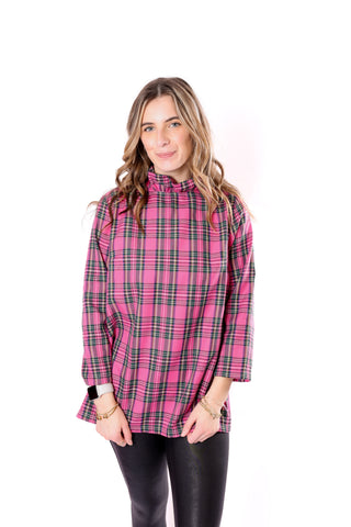 Woman wearing a pink plaid shirt with a ruffle neck and 3/4 sleeves