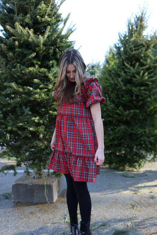 Woman wearing Belle Dress in red tartan plaid with puff sleeves, styled for the holidays.