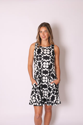 Woman wearing sleeveless A-line dress with pockets in black and white geometric floral print