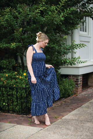 Woman wearing navy blue maxi dress with little white squares