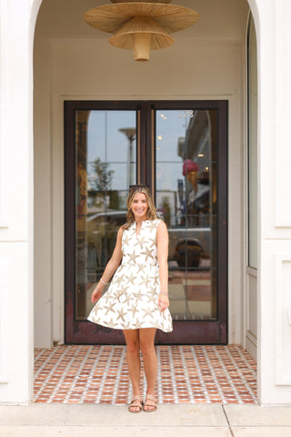 Lifestyle image of Maddie Dress in pink starfish print, styled for summer outings.