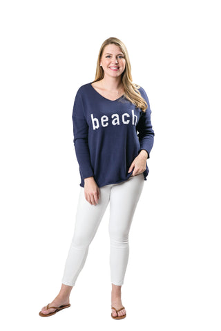 Woman wearing a navy blue 'beach' sweater. 
