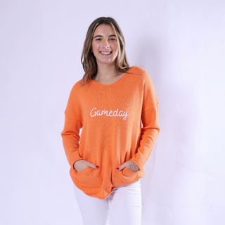 Bright orange sweater with white gameday  lettering and pockets