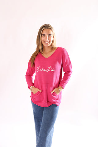 Woman wearing a pink 'Lake Life' sweater embroidered on it