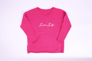 Close-up of pink 'Lake Life' sweater embroidered on it