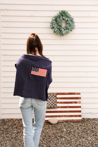 Woman wearing a navy blue sweatshirt with an American flag design