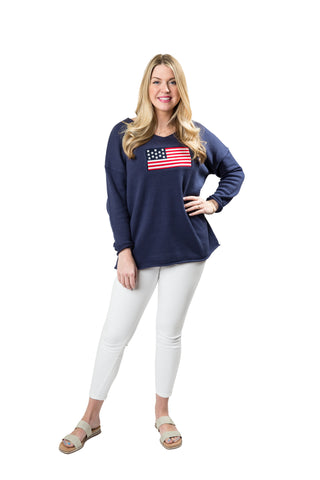 Woman wearing a navy blue sweatshirt with an American flag design on a white background