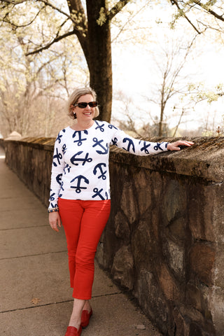Woman wearing a white sweater with blue anchor patterns 