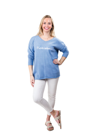 Woman wearing a blue 'Pickleball' shirt on a white background