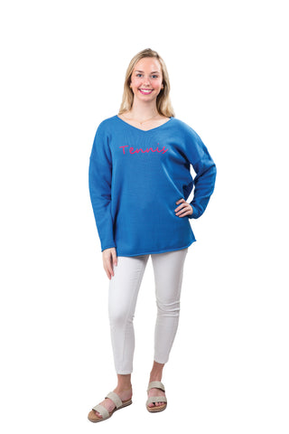 Woman wearing a blue sweater with pink text on a white background