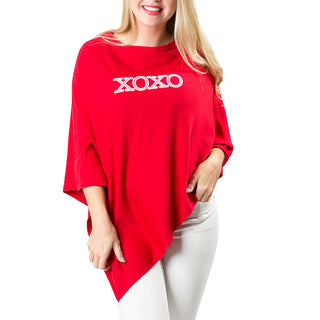 XOXO in pink and white embroidered block letters on red knit poncho shawl