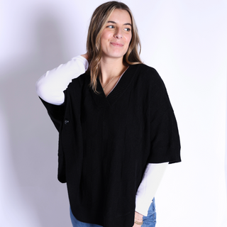 Black cable knit capelet with button sleeve closure