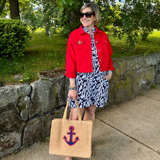 Women wearing red jean jacket over navy and white printed dress