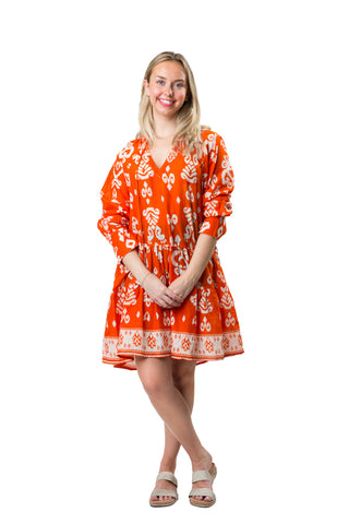 Orange and white paisley pattern tiered long sleeve tunic dress with a split neck and tassel ties