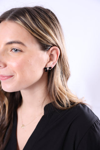 Close-up of a woman wearing earrings with a plain background
