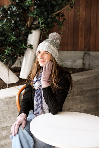 Woman wearing lavender Ethel solid color gloves with X-stitched detail, styled with a knit hat and scarf.