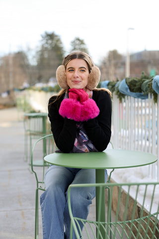 Woman wearing magenta Gabrielle gloves with faux fur cuffs, sitting outdoors – chic winter accessory