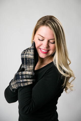 Woman wearing plaid gloves against a plain background