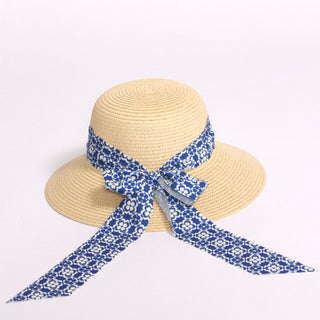 Straw hat with a blue geometric floral patterned ribbon