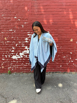 Woman wearing blue reversible ruana wrap and blue plaid dawn glove